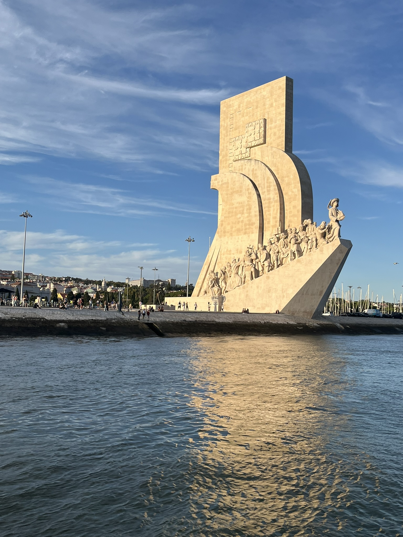 Vista lateral do Padrão dos Descobrimentos em Belém, Lisboa, captada a partir do Rio Tejo com reflexos na água.